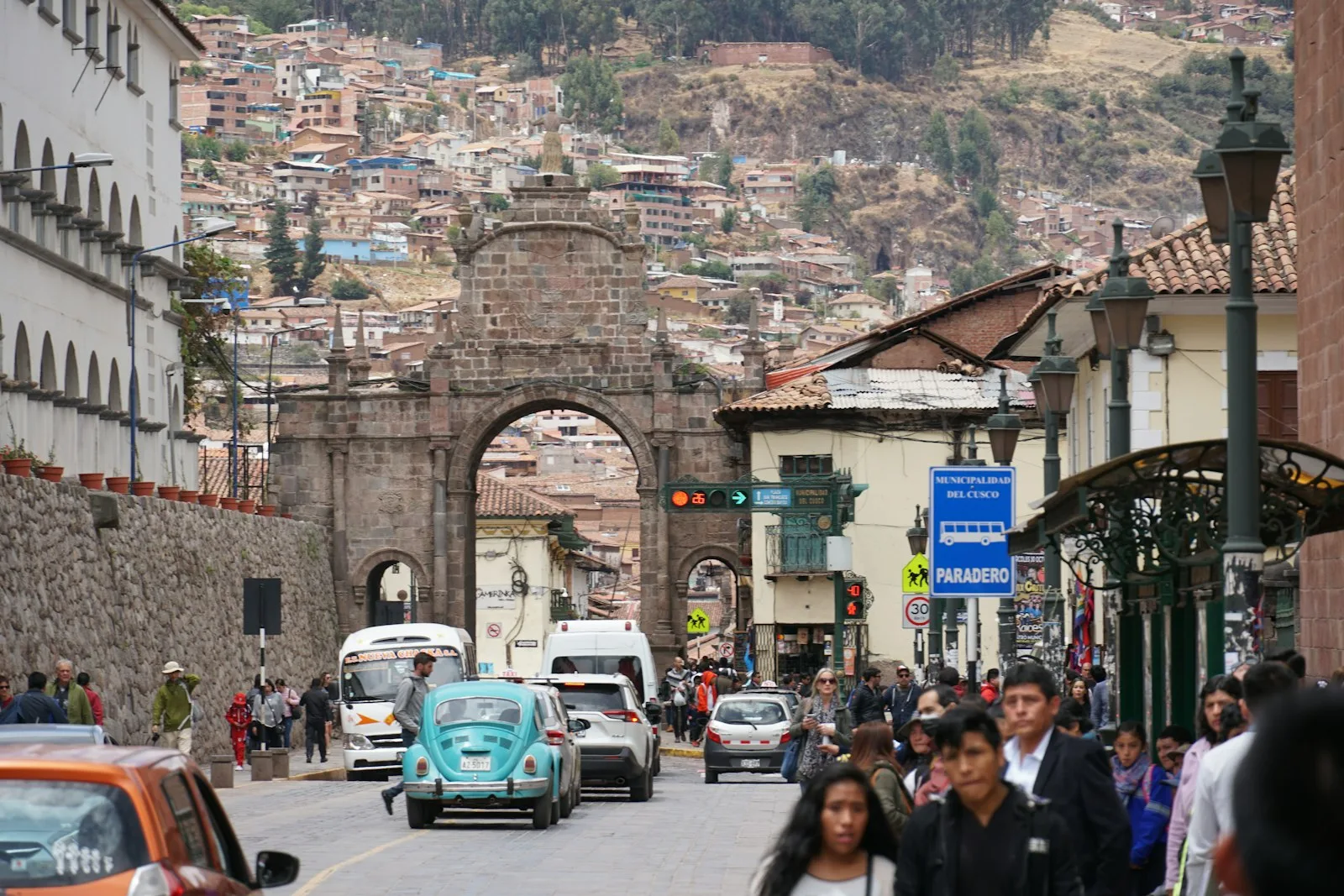 People walking down a street between old buildings